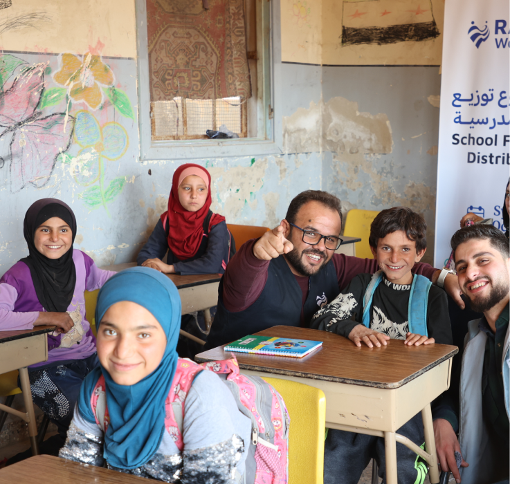 Children and teacher in classroom - School Furniture Distribution
